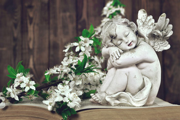 Guardian angel and spring branches on vintage book