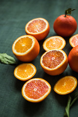 Summer concept. Juicy citrus fruits. Ripe oranges on green background close up.