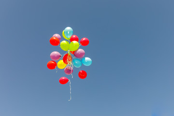 Big group multicolored balloons flying at sky