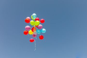 Obraz na płótnie Canvas Big group multicolored balloons flying at sky
