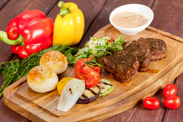  juicy, fried, tender steak with vegetables and sauces on a special stand