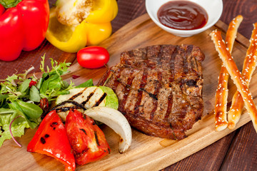  juicy, fried, tender steak with vegetables and sauces on a special stand