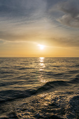 Fototapeta premium Waves astern of the yacht during orange sunset