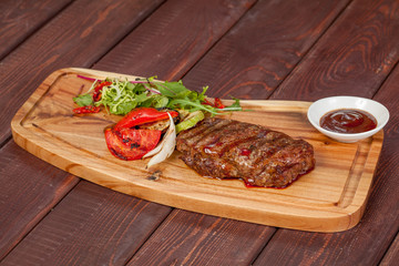  juicy, fried, tender steak with vegetables and sauces on a special stand