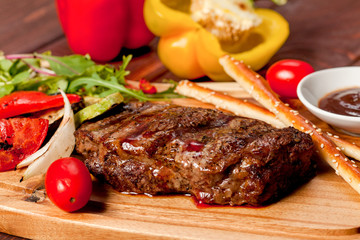  juicy, fried, tender steak with vegetables and sauces on a special stand