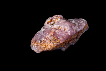 Macro pink Smithsonite mineral stone on microcline on black background