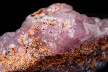 Macro pink Smithsonite mineral stone on microcline on black background
