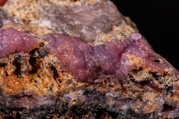 Macro pink Smithsonite mineral stone on microcline on black background