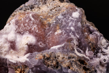 Macro pink Smithsonite mineral stone on microcline on black background