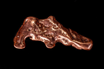 Macro mineral stone of a copper nugget on a microcline on a black background