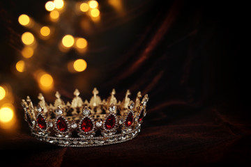 photo of gold crown over gothic dark silk background. Medieval period concept. © tomertu