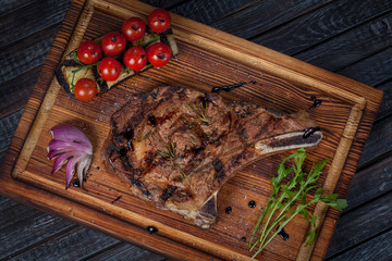  juicy, fried, tender steak with vegetables and sauces on a special stand