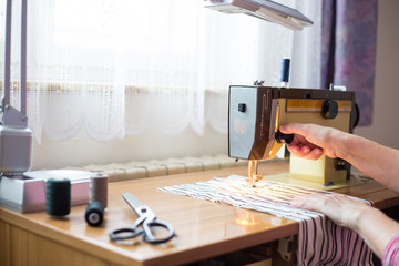 woman hands using sewing machine on a sewing manufacture, sewing process