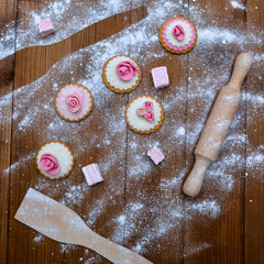 Handmade homemade cookies, rolling pin and flour on a wooden background - top view. Cooking sweets.
