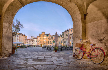 Lucca, Italy. View of Piazza dell'Anfiteatro square through the arch - obrazy, fototapety, plakaty