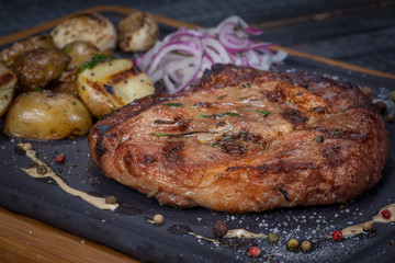  juicy, fried, tender steak with vegetables and sauces on a special stand