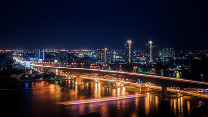 Fototapeta na wymiar Urban Night Scene Skyline Bright Lights Bridge River Generic City Landscape
