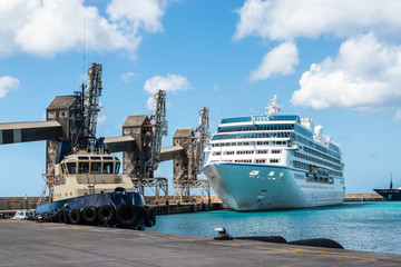 Bridgetown harbor, Barbados. Tugboat and cruise ship in port. - obrazy, fototapety, plakaty