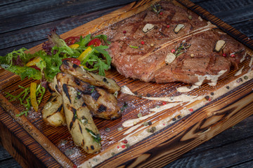  juicy, fried, tender steak with vegetables and sauces on a special stand