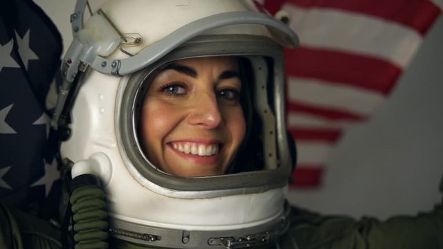Close up shot of astronaut woman with the helmet visor up relaxing and breathing deep