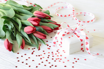Bouquet of red tulips and gift on the white wooden background, Valentines Day concept.