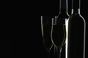  wine bottle and wine glass in a black background
