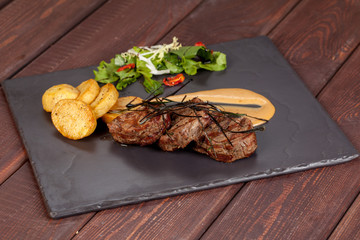  juicy, fried, tender steak with vegetables and sauces on a special stand