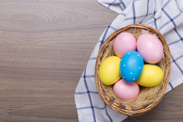 Easter eggs in the basket on wooden background