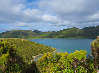 Fototapeta na wymiar Landscape with beautiful blue crater lake Lagoa do Fogo from viewpoint Miradouro da Lagoa do Fogo. Lake of Fire is the highest lake of Sao Miguel island, surrounded by Natural Reserve green forest