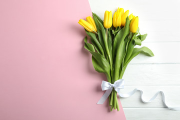 Beautiful fresh yellow tulips on color background, top view. Space for text