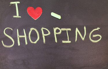 I love shopping phrase handwritten on the  blackboard with red heart 