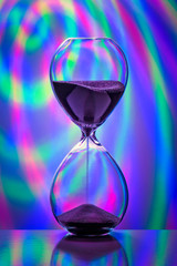 Hourglass on a multi-colored background. Close-up. - 248518885