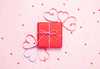 Pink holiday Valentine's background with present gift box and little hearts on background. Valentine's day greeting concept. Top view, flat lay.