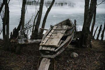 Old wooden boat is lying on the ground