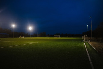 Fototapeta na wymiar Football field at night illuminated by spotlights