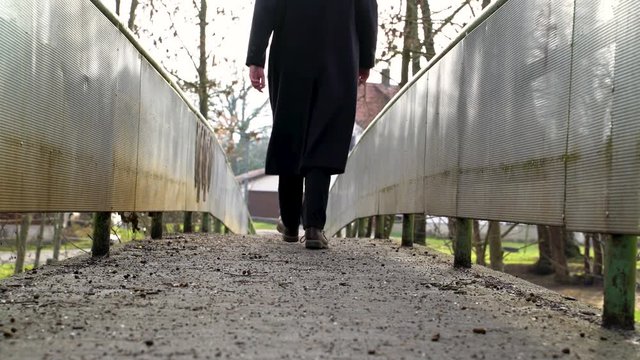 Image of man crossing small bridge at countryside, Heuchlingen, Germany.