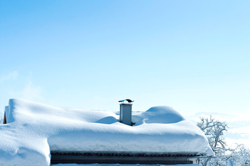Snowy roof of a countryside covered with snow on the blue sky. - Powered by Adobe
