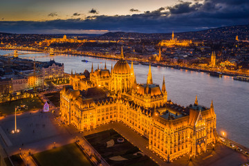 Budapest, Hungary - Aerial view of the beautiful illuminated Parliament of Hungary at dusk with Szechenyi Chain Bridge, Fisherman's Bastion and other famous landmarks at background