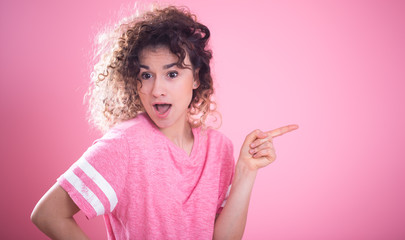 Portrait of young cute surprised girl with curly hair