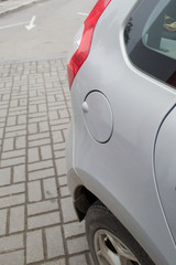 A close up of a petrol cap cover on a modern silver car