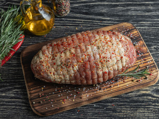 Raw pork roulade. Raw rolled meat enclosed in tied netting. Meat pulp for roasting