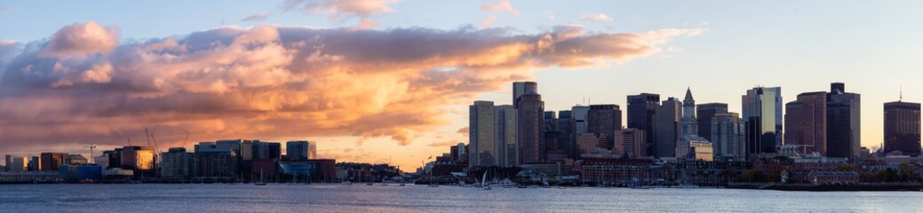 Striking panoramic cityscape of a modern Downtown City during a vibrant sunset. Taken from LoPresti Park, Boston, Capital of Massachusetts, United States.