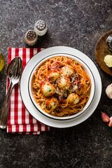 Italian pasta spaghetti with ricotta cheese balls in tomato sauce on the table with parmesan cheese. healthy traditional italian food for the whole family, party or restaurant menu