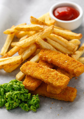 Fish fingers, mashed peas and chips fries. Traditional British fast food. served on crumpled paper