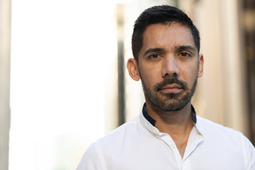 Obraz premium Young Latino Hispanic man in city serious face