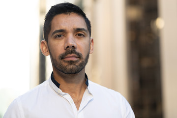 Obraz premium Young Latino Hispanic man in city serious face