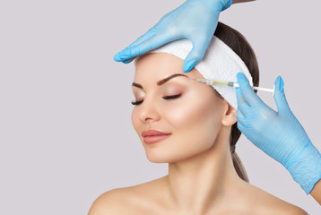 The doctor cosmetologist makes the Rejuvenating facial injections procedure for tightening and smoothing wrinkles on the face skin of a beautiful, young woman in a beauty salon.Cosmetology skin care.