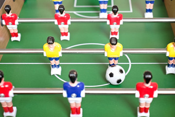 Table football game with yellow, red and blue plastic players.
