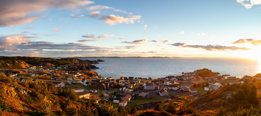 Panoramic view of a small town on the Atlantic Ocean Coast during a vibrant sunset. Taken in Crow Head, North Twillingate Island, Newfoundland and Labrador, Canada.