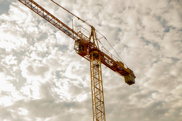 yellow construction crane in cloudy sky